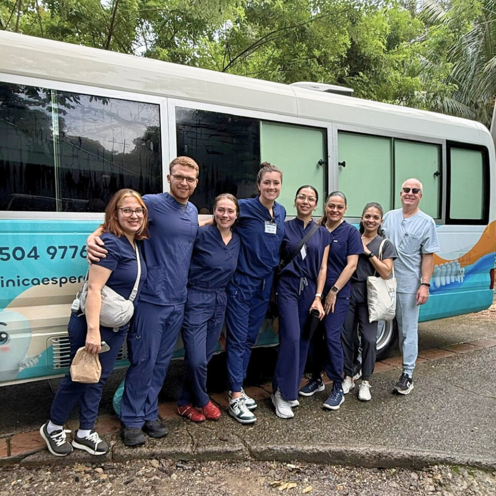 group of dental students and faculty in front of mobile dental bus