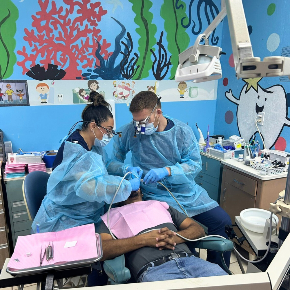 dental students work on a patient in community clinic