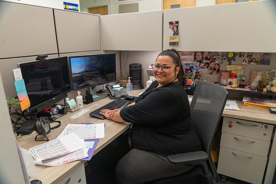 Agueda sitting at her desk