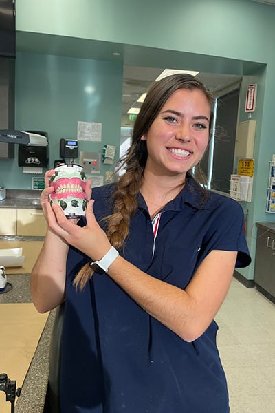 Dental student showing off denture mockup