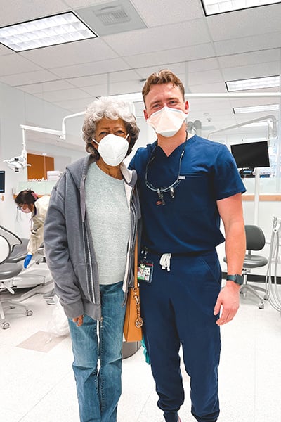 Dental student sanding with patient in masks