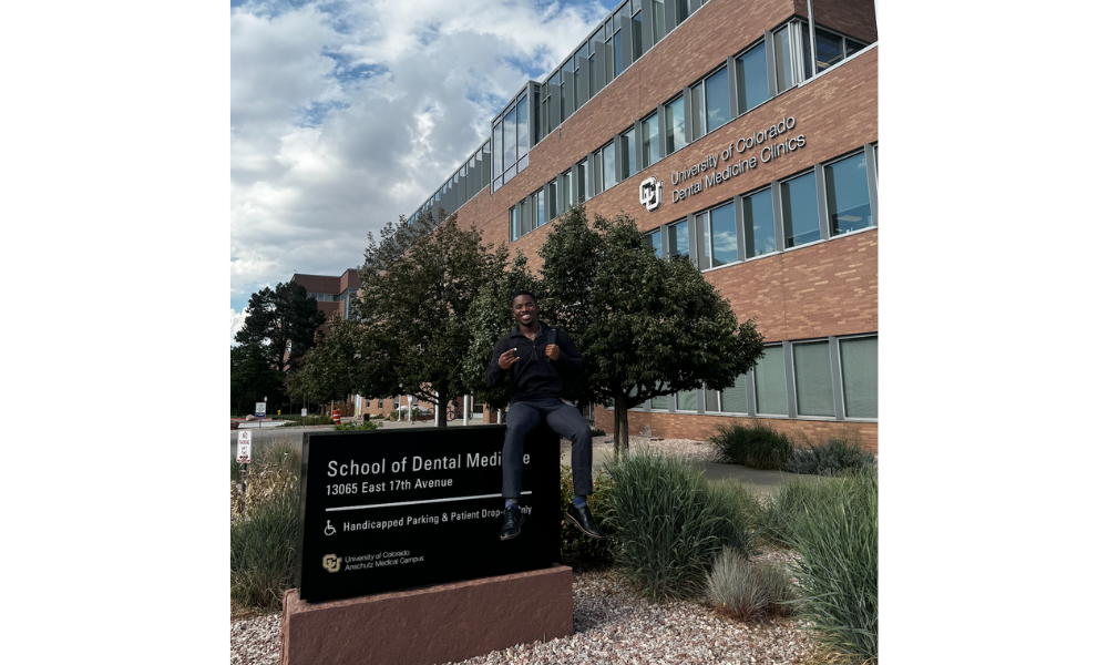 Demetrius Jelks in front of the School of Dental Medicine