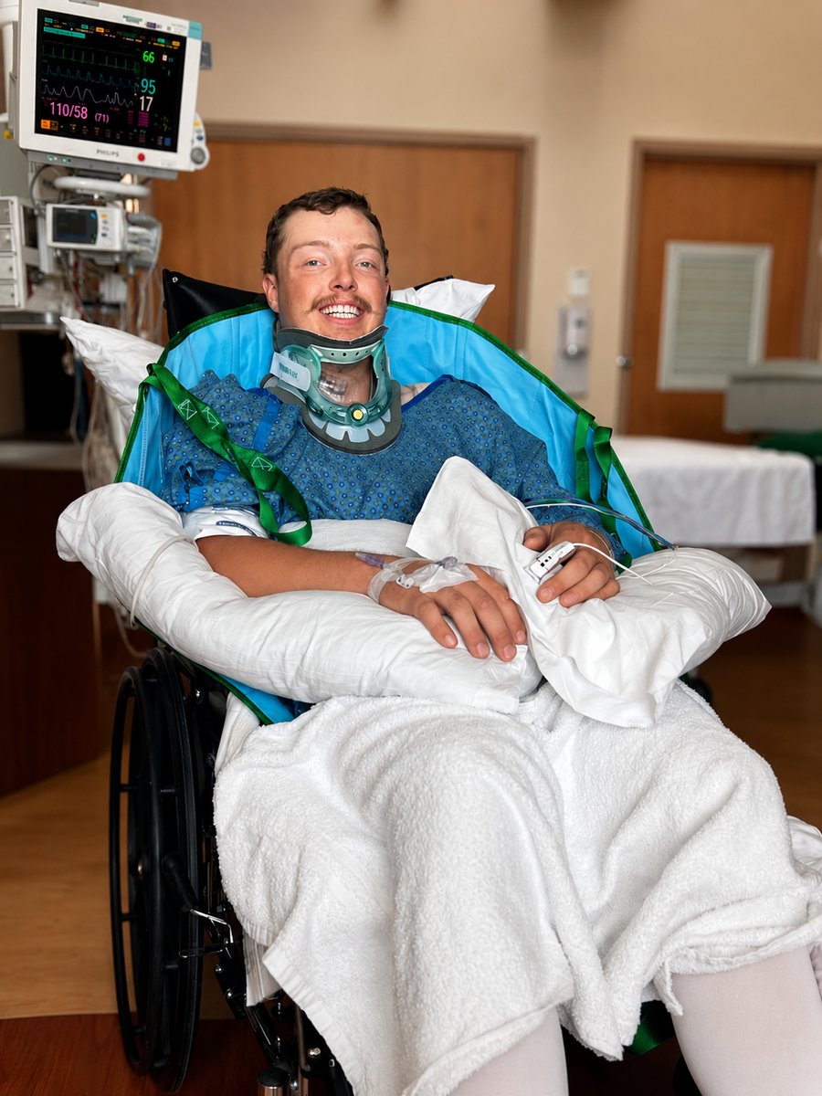 Northrup in a wheel chair with a neck brace in his hospital room.
