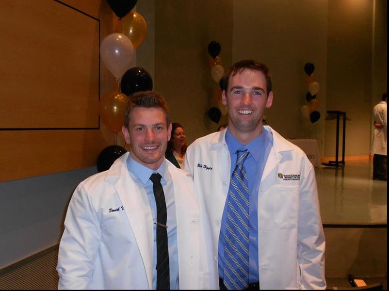 Two male dental students in their white coats