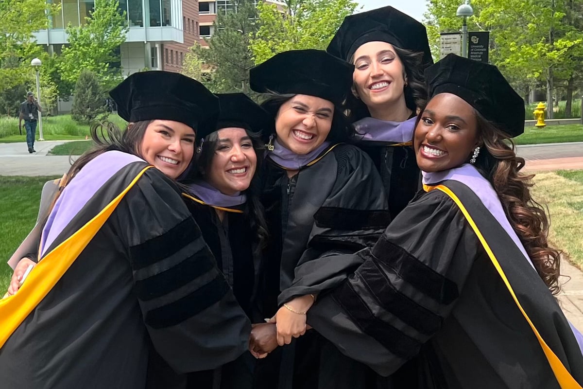 Group of five female graduates in caps, gowns and hoods