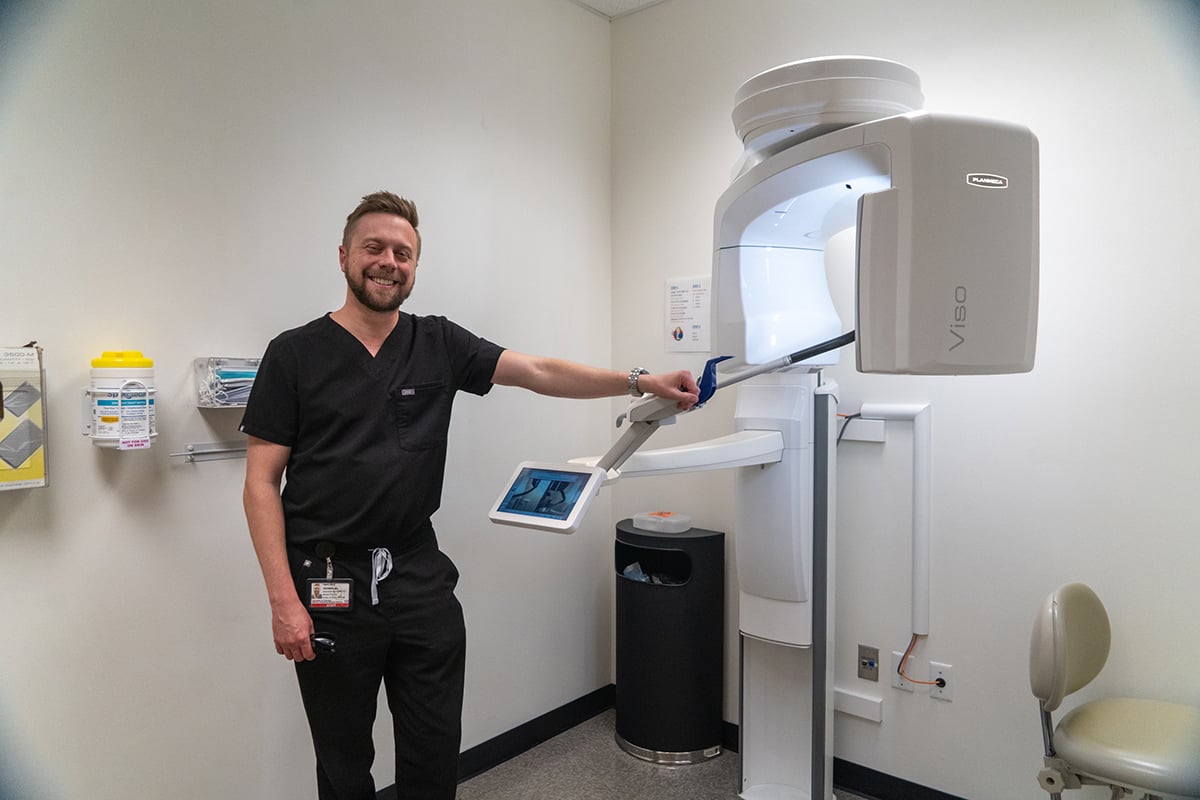 Taylor standing next to a CBCT machine